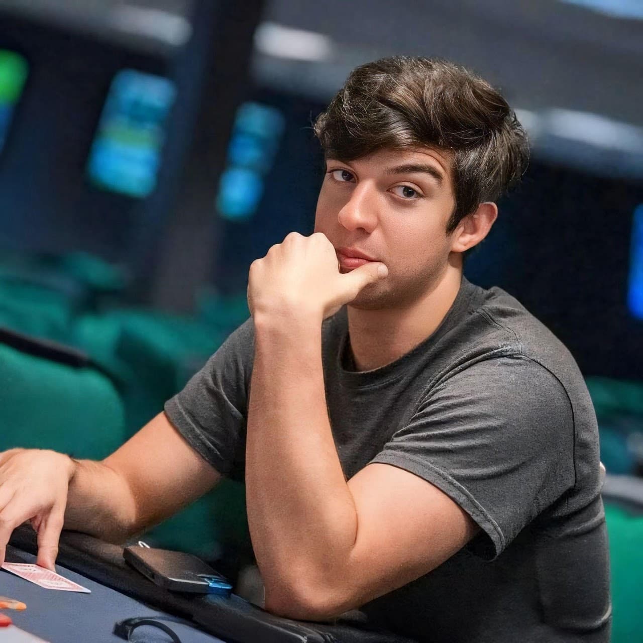 Ryan Estrada at a poker table, hand on his chin, deep in thought
